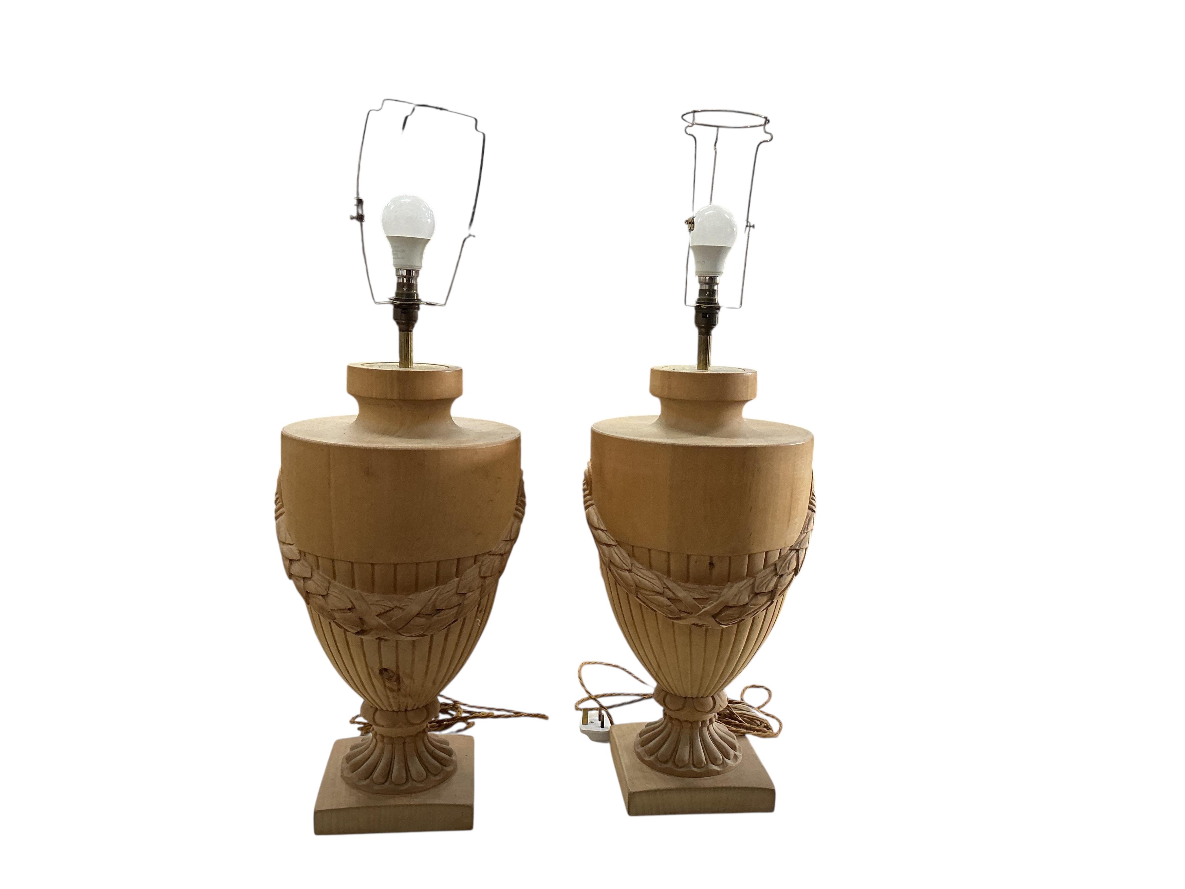 A pair of beech campana urn shaped lamps with shades, height including shades 90cm, Provenance: The late Kenneth Turner (1936-2025), celebrity florist, designer and perfume retailer, he received the Royal Warrant from th